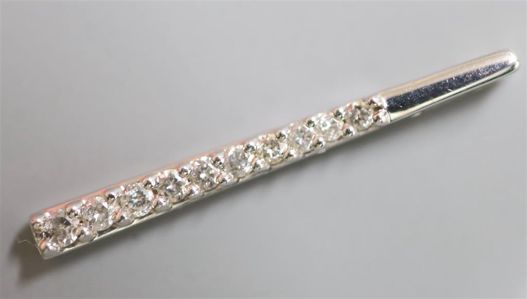 A modern 9ct white gold and ten stone diamond chip set line pendant,24mm, gross 0.6 grams.